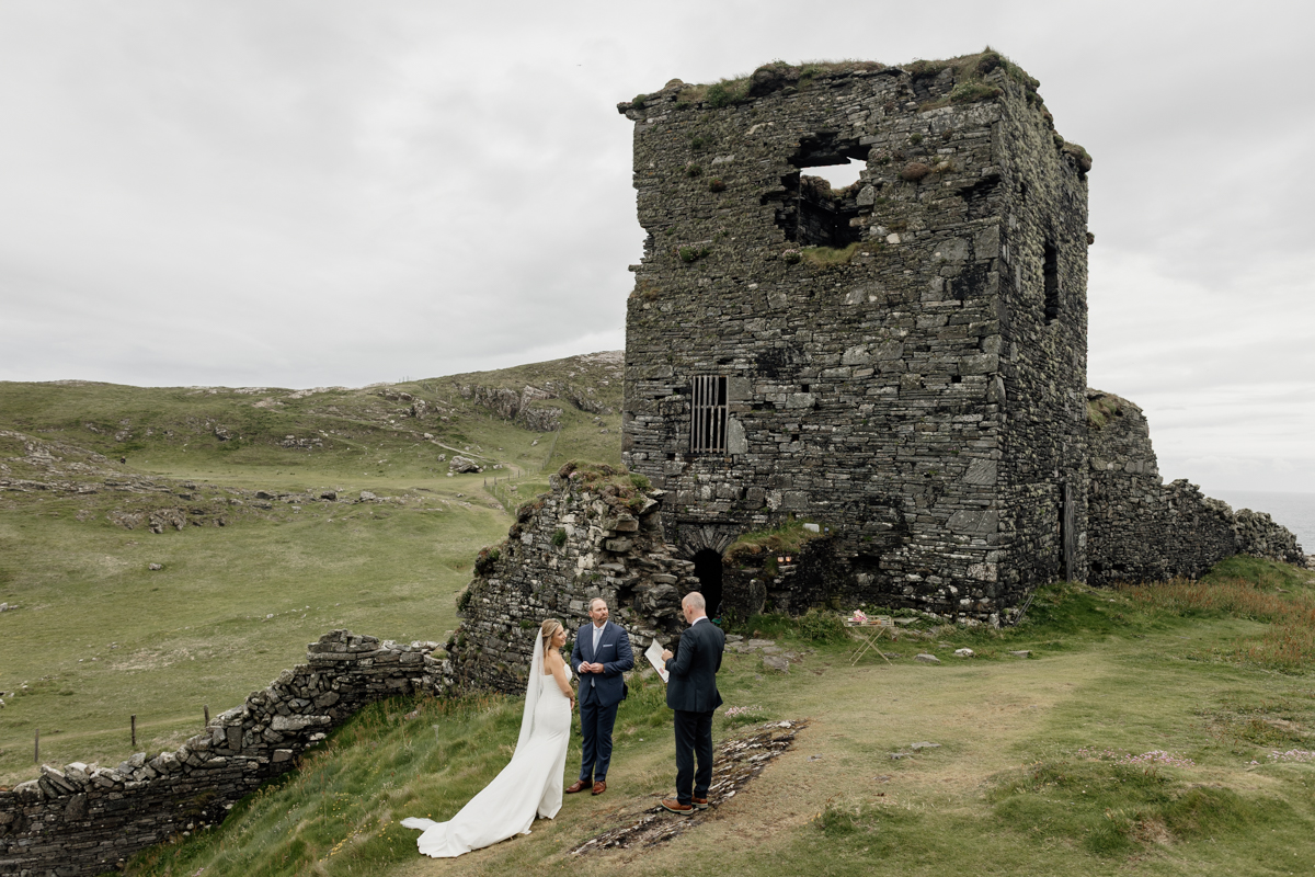 Wide shot of Three Castle Head ruins perched above the ocean, top place to elope in County Cork, Ireland.